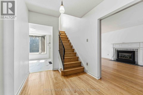 A spacious room with a staircase leading to the upper floor.