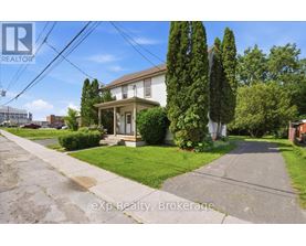 A house with a lawn and trees in front of it.