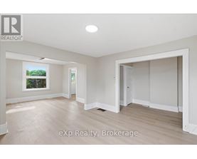 A spacious room with a window and a door leading to another room.