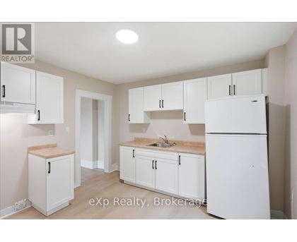 A kitchen with white cabinets and appliances.