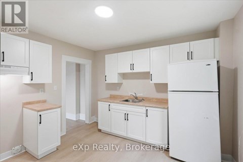 A kitchen with white cabinets and appliances.