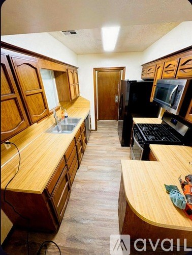A kitchen with wooden cabinets and a countertop with a sink.