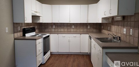 A kitchen with white cabinets and a black stove top oven.