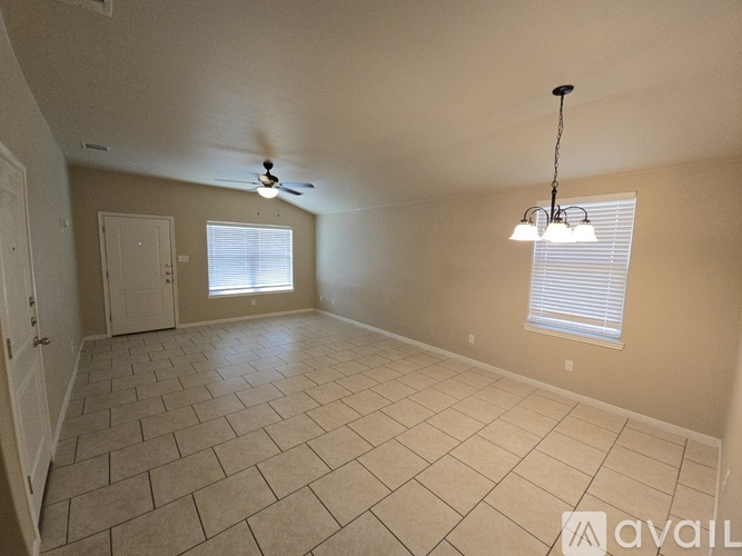 A spacious room with a ceiling fan and a hanging light fixture.