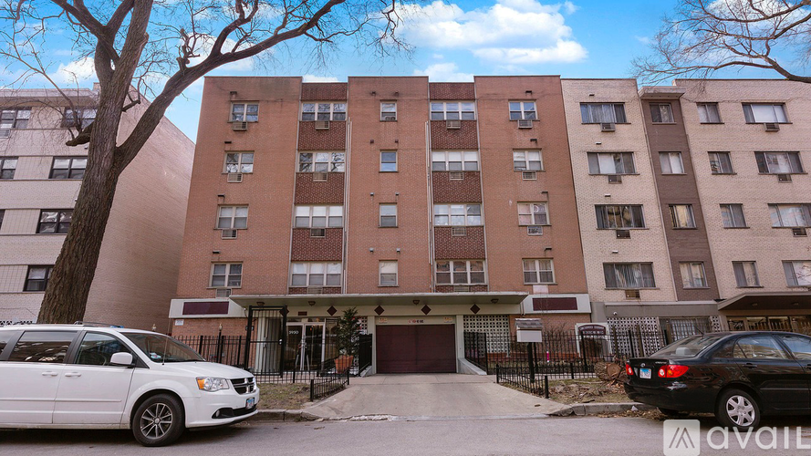 A white van is parked in front of a brick apartment building.