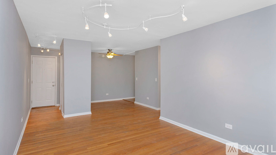 A room with wooden floors and a ceiling fan.