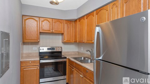 A kitchen with wooden cabinets and a stainless steel refrigerator.