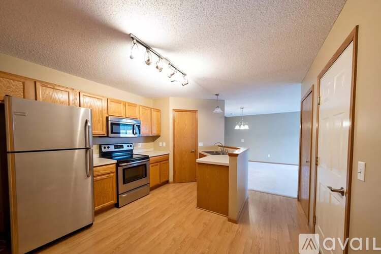 A kitchen with wooden cabinets and a stainless steel refrigerator.
