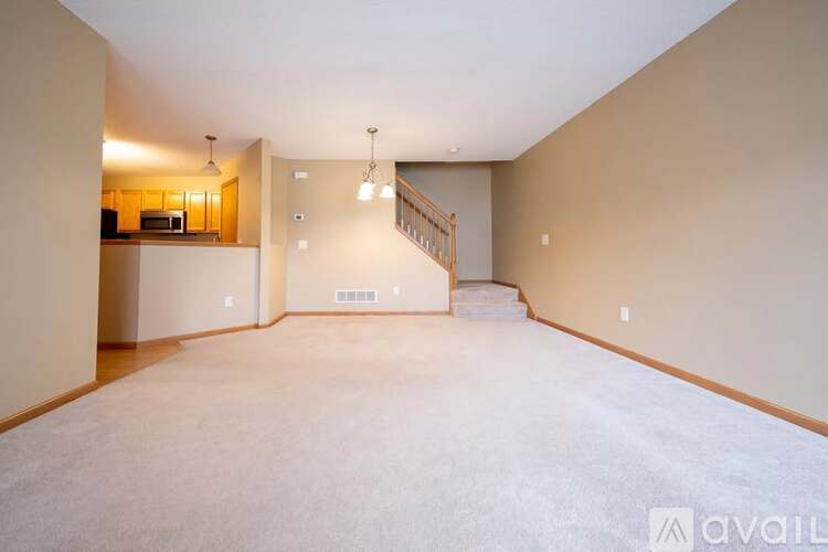 A spacious living room with a staircase leading to the upper floor.