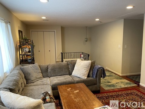 A living room with a grey couch and a wooden coffee table.