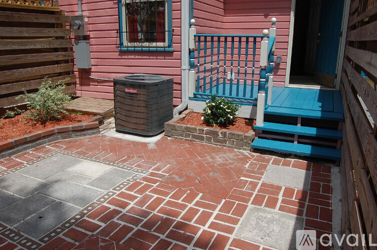 A pink house with a blue gate and a brick walkway.