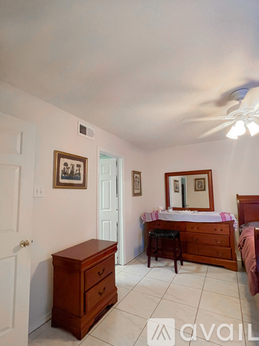 A bedroom with a bed, dresser, and mirror.