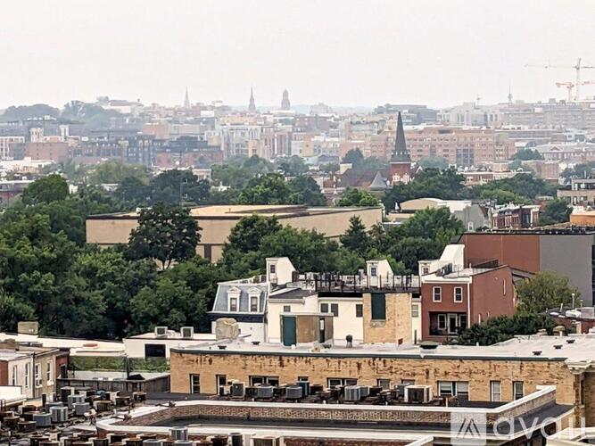 A cityscape with buildings and trees in the foreground.