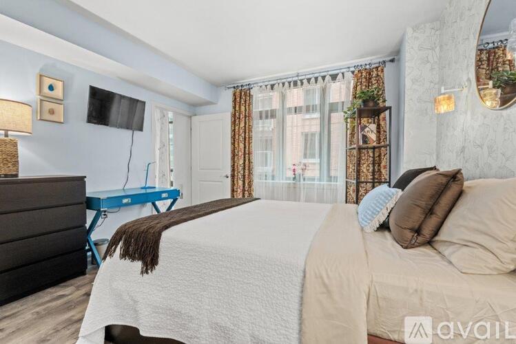 A bedroom with a large bed and a flat screen TV mounted on the wall.