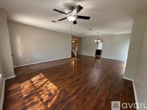 A room with wooden flooring and a ceiling fan.