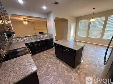 A kitchen with granite countertops and a refrigerator.