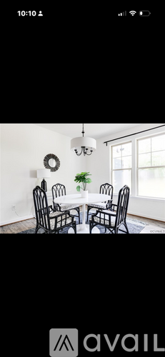 A dining room with a white table and chairs.
