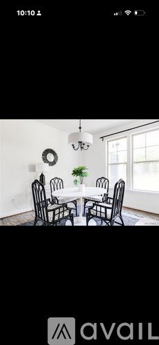 A dining room with a white table and chairs.