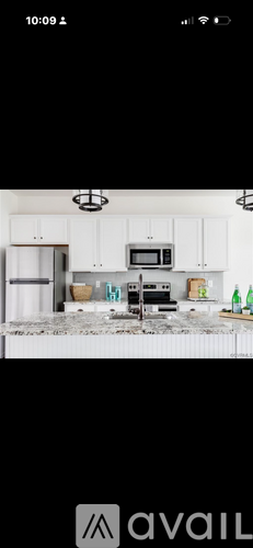 A kitchen with white cabinets and a black countertop.