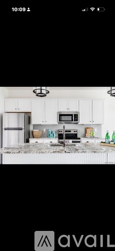 A kitchen with white cabinets and a black countertop.