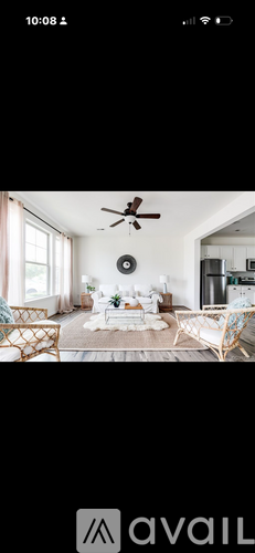 A living room with a white couch and a ceiling fan.
