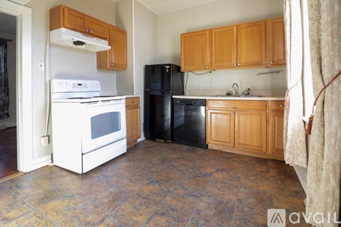 A kitchen with a white stove and black refrigerator.