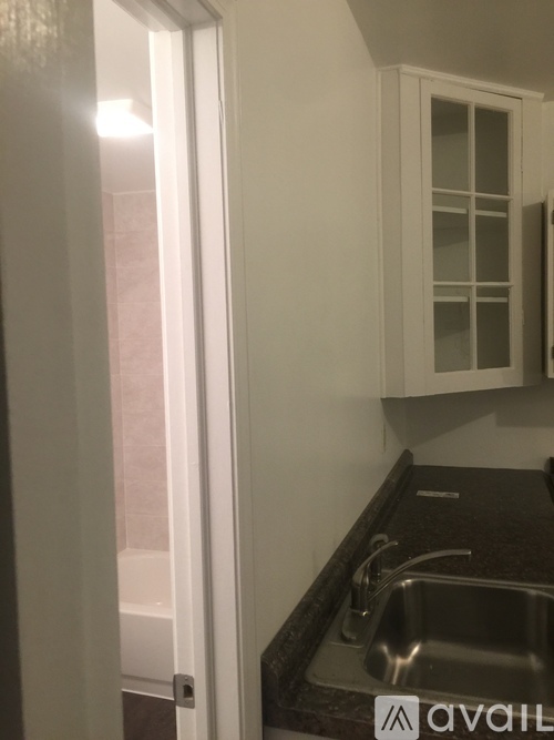 A white door is open to a kitchen with a sink.
