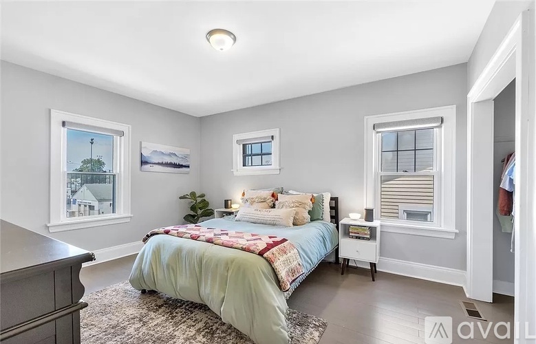 A bedroom with a bed, nightstand, and window.