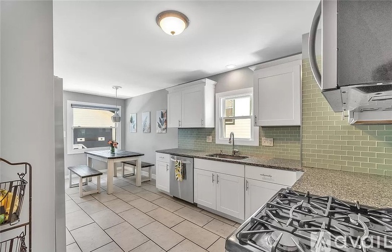 A kitchen with white cabinets and a black stove top.