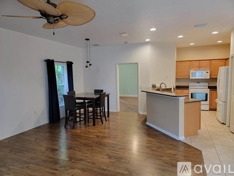 A kitchen with a dining table and chairs in the middle of the room.