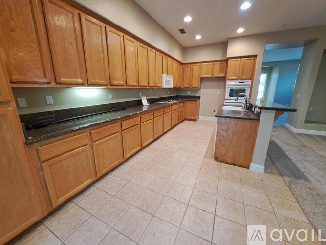 A kitchen with wooden cabinets and a tiled floor.