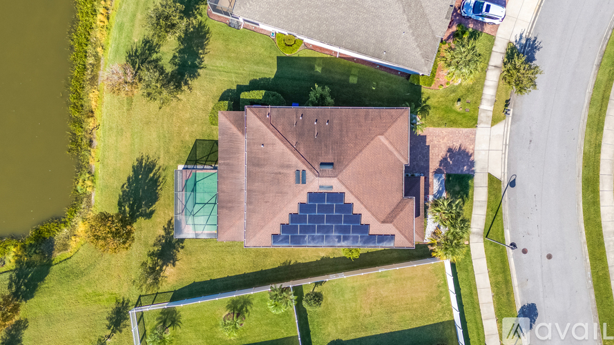 A house with a green lawn and a basketball court.