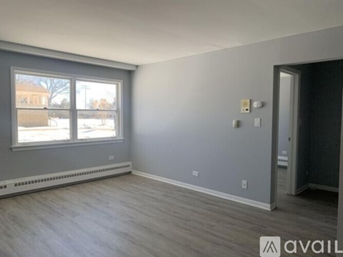 A room with a window and a door is available for rent.