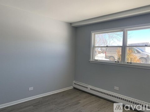 A room with a window and a grey wall.