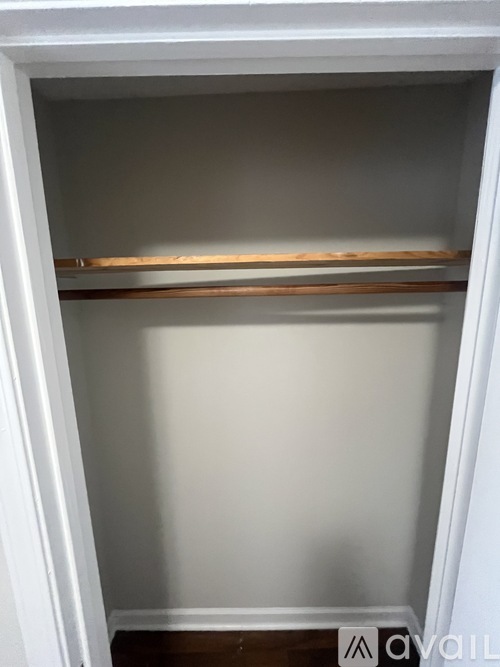 A white open closet with a shelf.