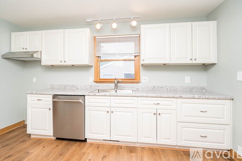 A kitchen with white cabinets and a granite countertop.