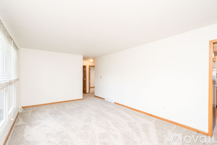 A spacious room with a carpeted floor and white walls.