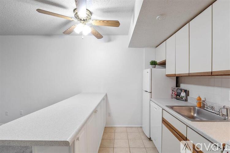 A kitchen with white cabinets and a ceiling fan.