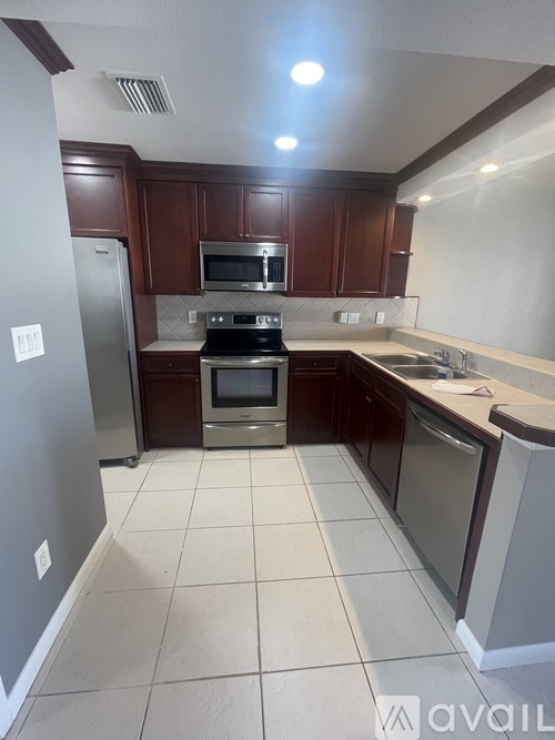 A kitchen with brown cabinets and a white fridge.