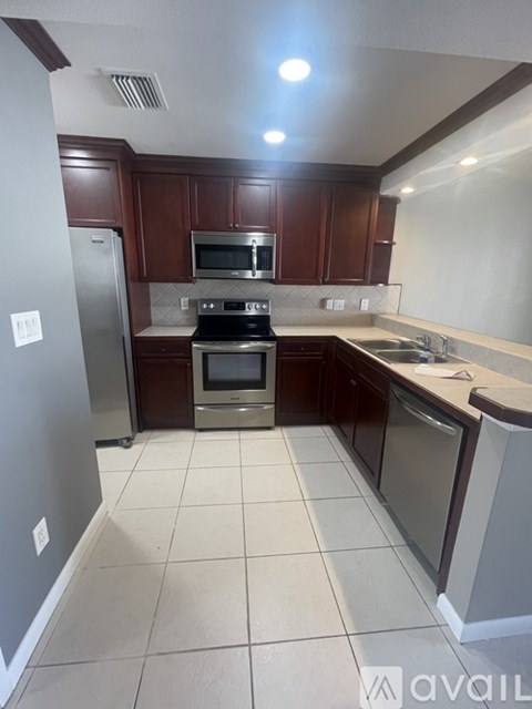 A kitchen with brown cabinets and a white fridge.