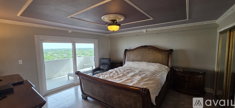A bedroom with a large bed and a view of the city.