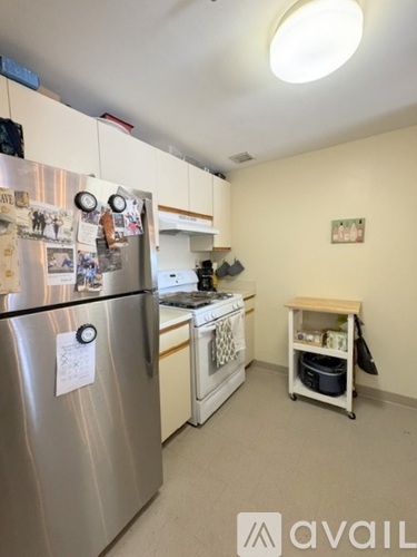 A kitchen with a stainless steel refrigerator and a washing machine.