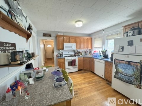 A kitchen with wooden cabinets and a white fridge.