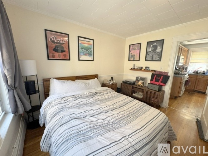 A bedroom with a large bed and pictures on the wall.