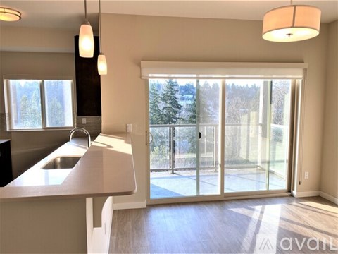 A kitchen with a sink and a window overlooking a snowy landscape.