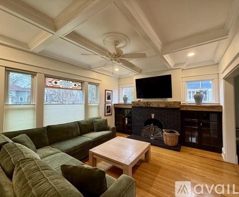 A living room with a green couch and a fireplace.
