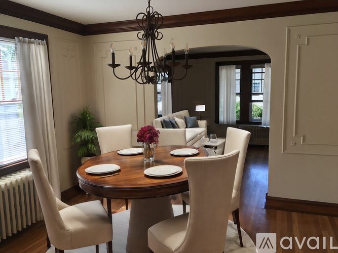 A dining room with a round table and chairs.