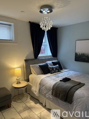 A bedroom with a large bed and a chandelier.