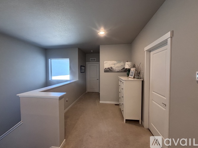 A bedroom with a dresser and a window.