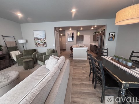 A living room with a grey sofa and a wooden dining table.
